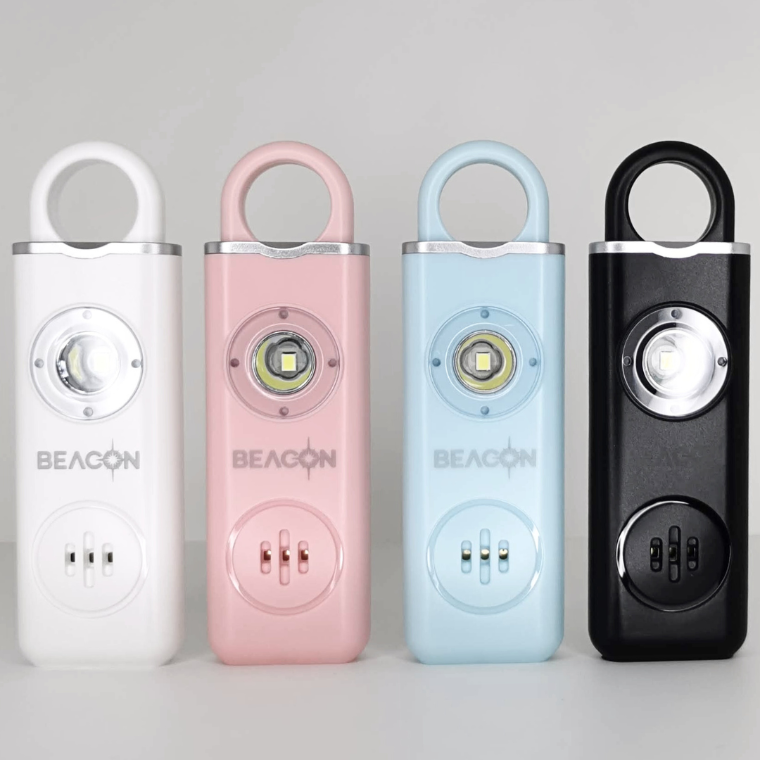 Picture of Beacon Personal Alarms in White, Pink, Blue and Black. Standing in a row, one next to another.