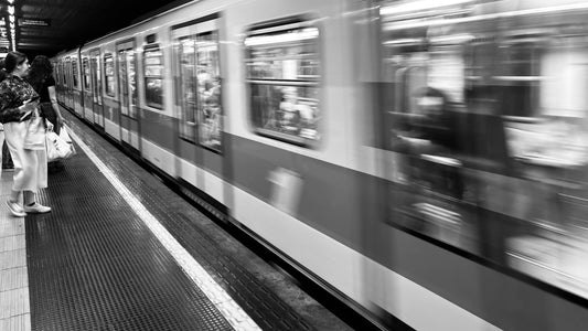 Black and white artistic motion blurred photo of a train arriving at a station